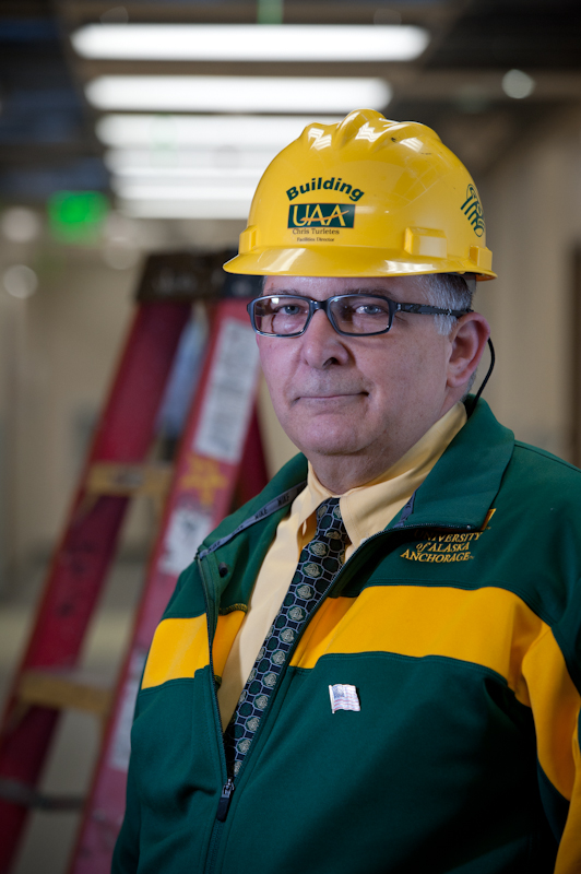 Headshot of Chris Turletes. He is wearing Green and Gold attire with construction activity in the background.