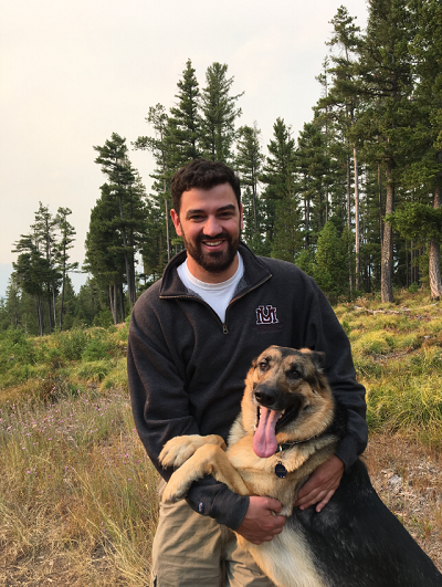 white male with beard holding a german shepard
