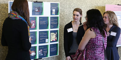 Dr. Lupfer reviewing students poster at a conference