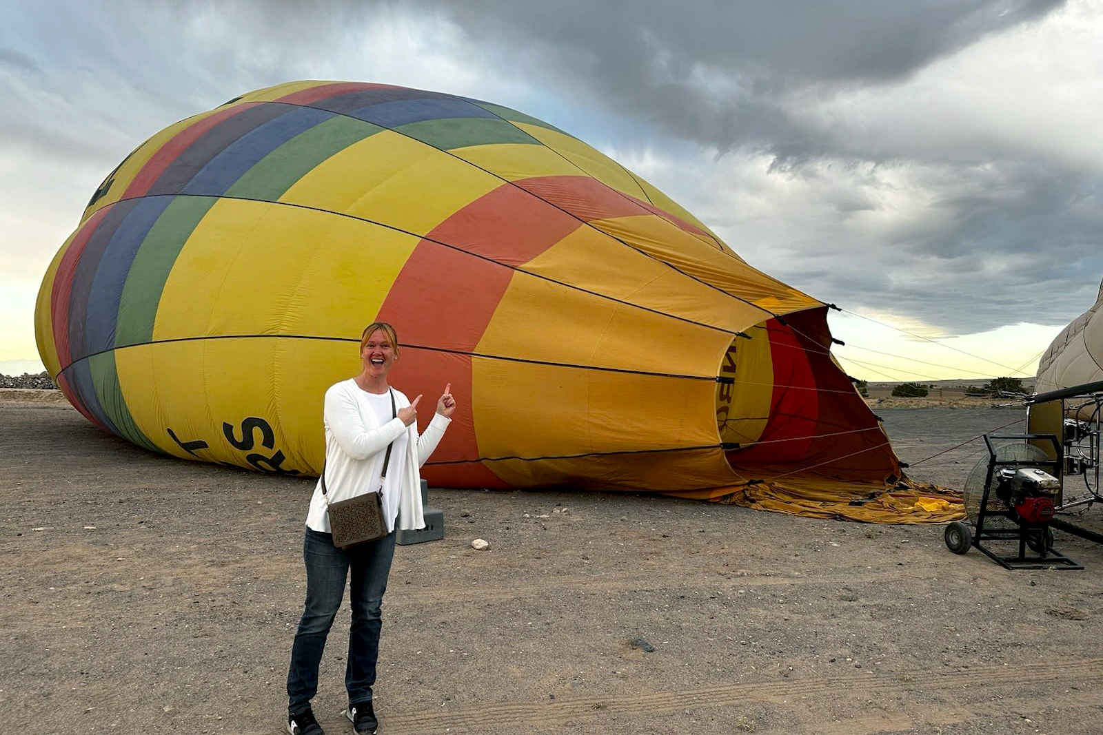 Brittney Howell pointing to hot air balloon being inflated