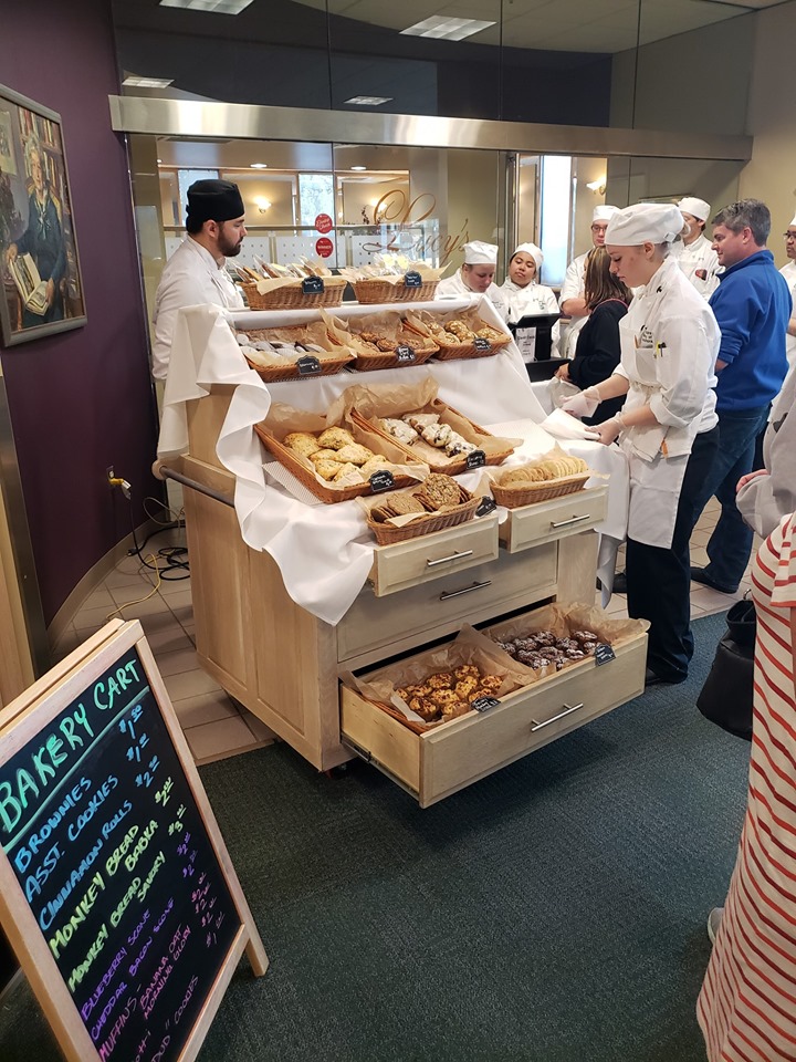 People lined up to purchase baked goods from UAA Culinary Students bakery cart