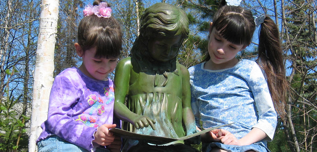 two girls reading with statue