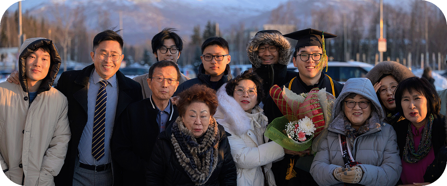 Jihun Kim, AVTE BS, and family outside the arena after UAA's Fall 2025 Commencement in the Alaska Airlines Center.