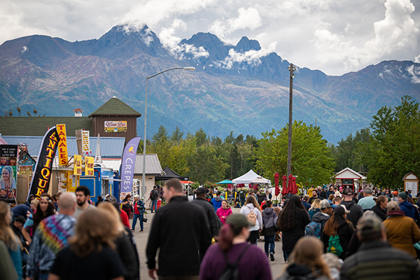 UAA Day at the Alaska State Fair, showing booths and people walking around with mountains in the background.