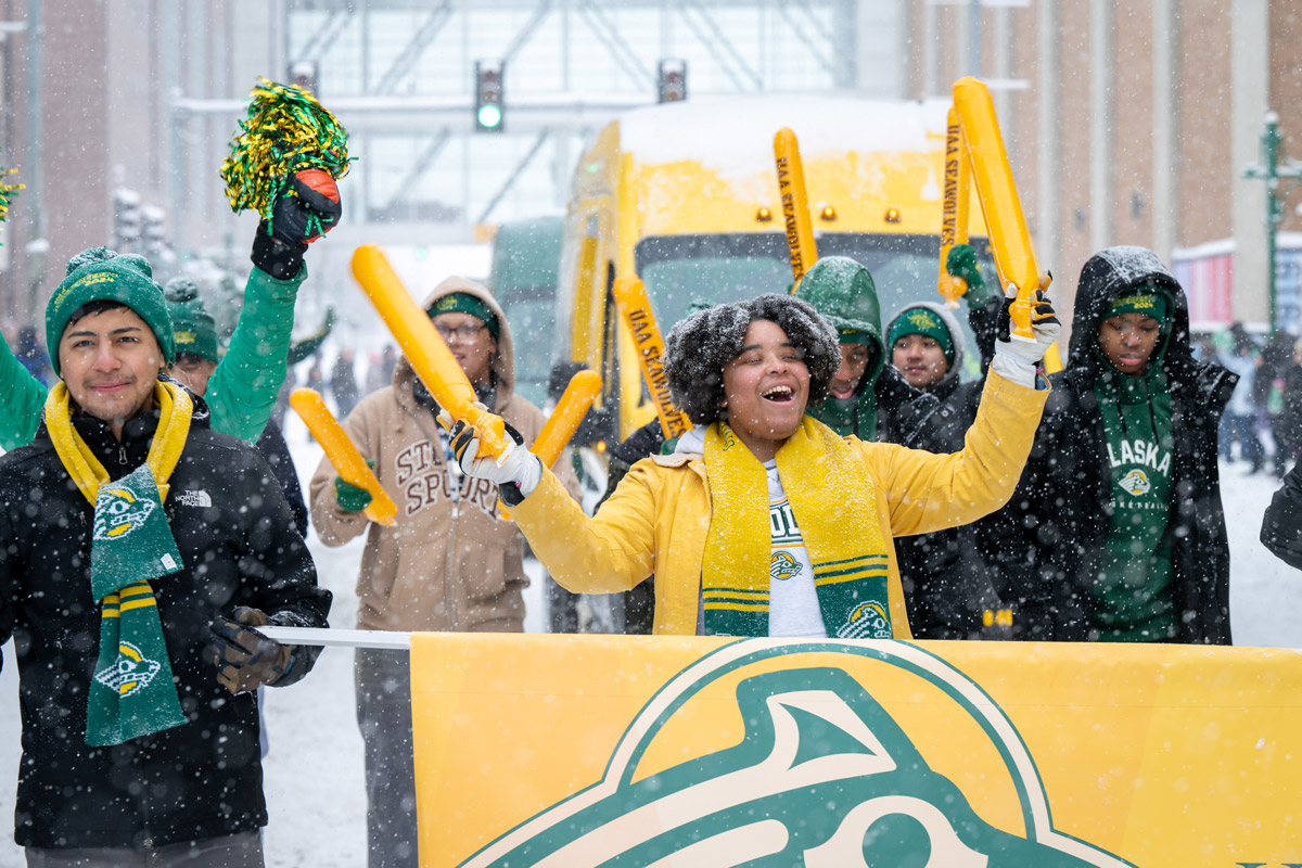Eliana Deas leads as UAA students, student athletes, staff and faculty march through downtown Anchorage in the Fur Rondy Grand Parade.