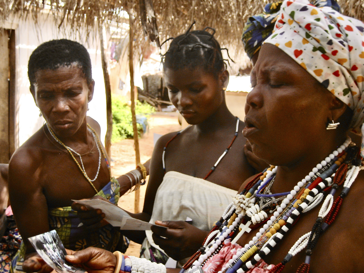 Dzodze women look at pictures from Perico, Cuba, image by Brian Jeffery