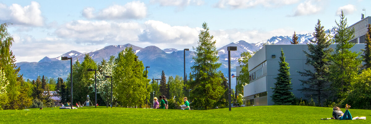 UAA campus in summer with mountains in background.