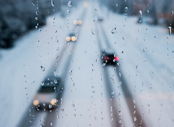 Raindrops flow down a window pane