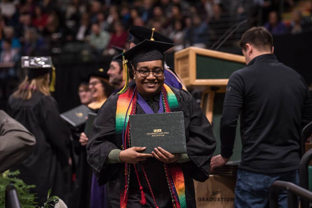 UAA student receiving diploma during graduation