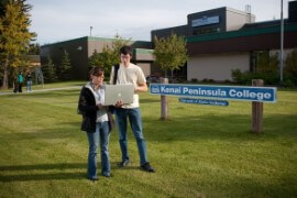 Students stand in front of Kenai Peninsula College sign