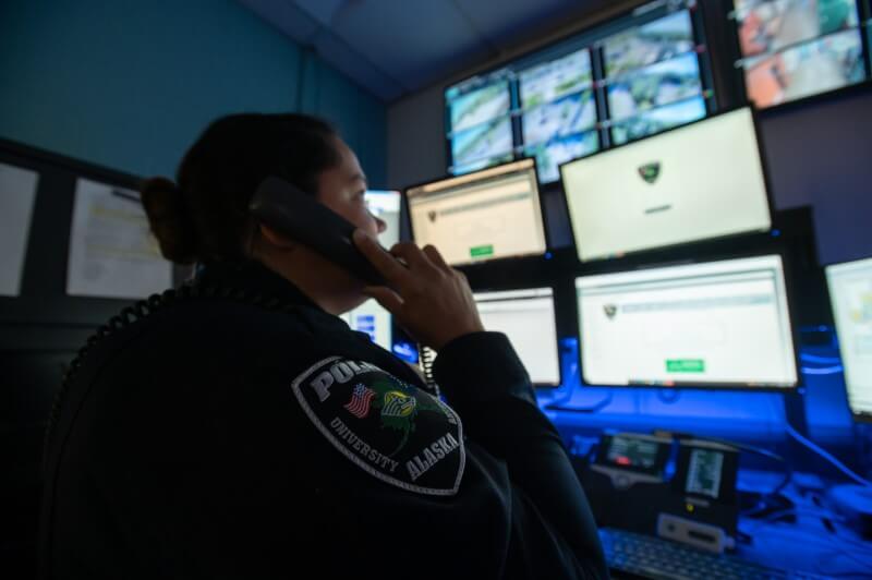 Officer speaking on the telephone while viewing computer screens