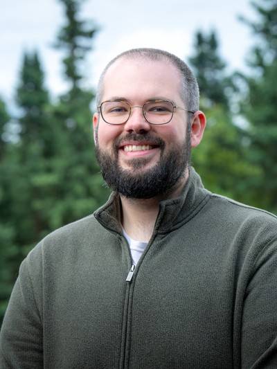 Ben headshot in green collared sweatshirt
