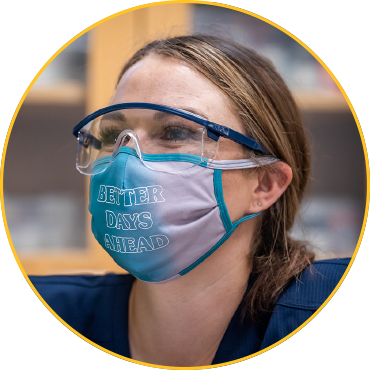 Headshot of student wearing blue scrubs, protective eye wear and a mask that says, "Better Days Ahead."