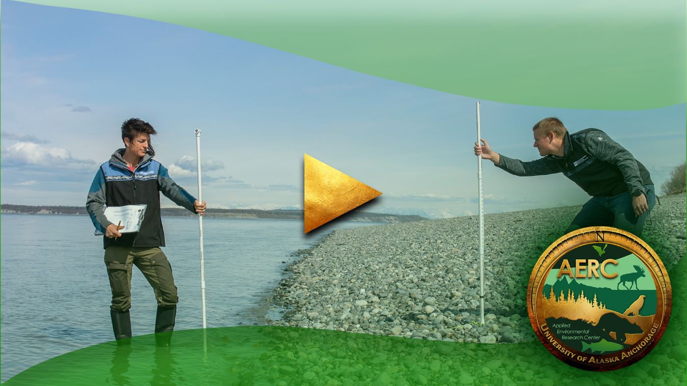 Two researchers hold vertical pipes while standing on a rocky beach