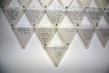 Stacked, upsidedown triangle sculptures with indiscernable writing