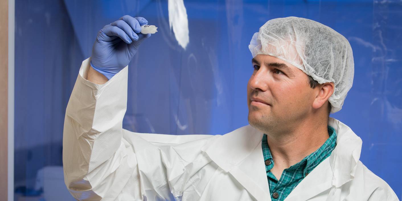 Dr. Brandon Briggs holding microbes modified using CRISPR.