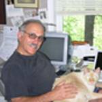 CWLA Faculty Member Richard Chiappone seated at a desk with a cat on his lap