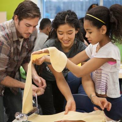 UAA students prepare ravioli dough with fifth grade students at Mountain View Elementary as part of their community-focused philosophy course on food justice