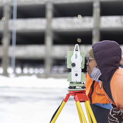 Geomatics student surveys the ECB parkinglot covered in snow..