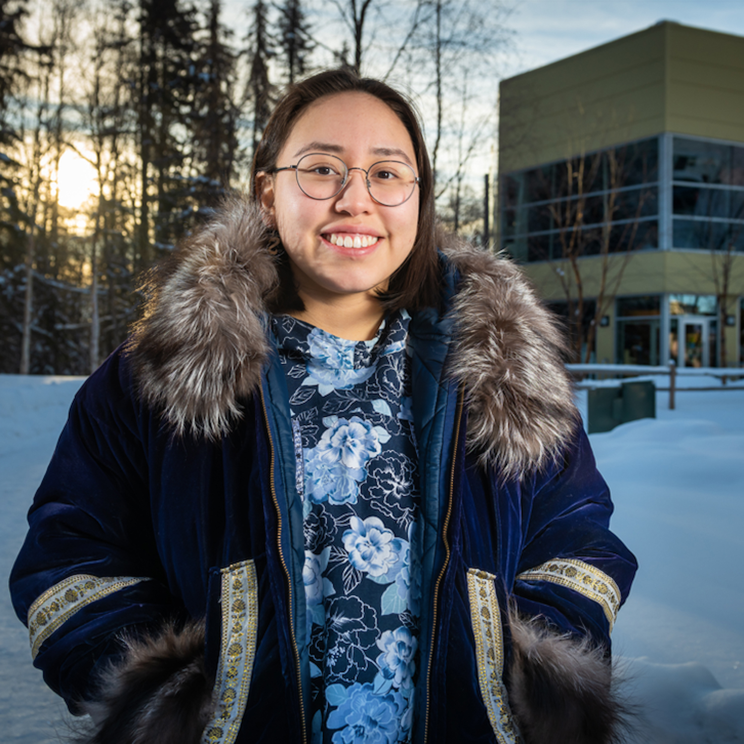 Student, Katherine Sakeagak, stands in front of the ANSEP building covered in snow.