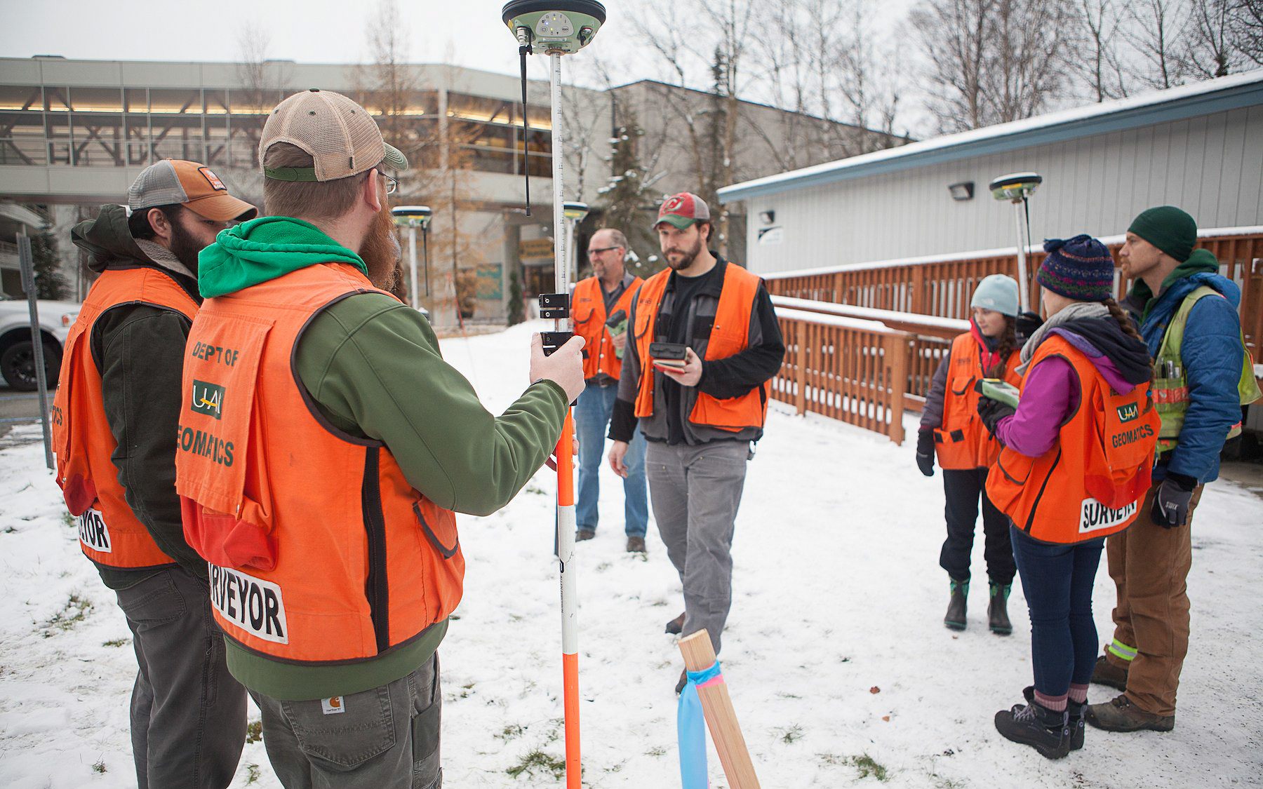 Students with surveying equipment outside in the snow