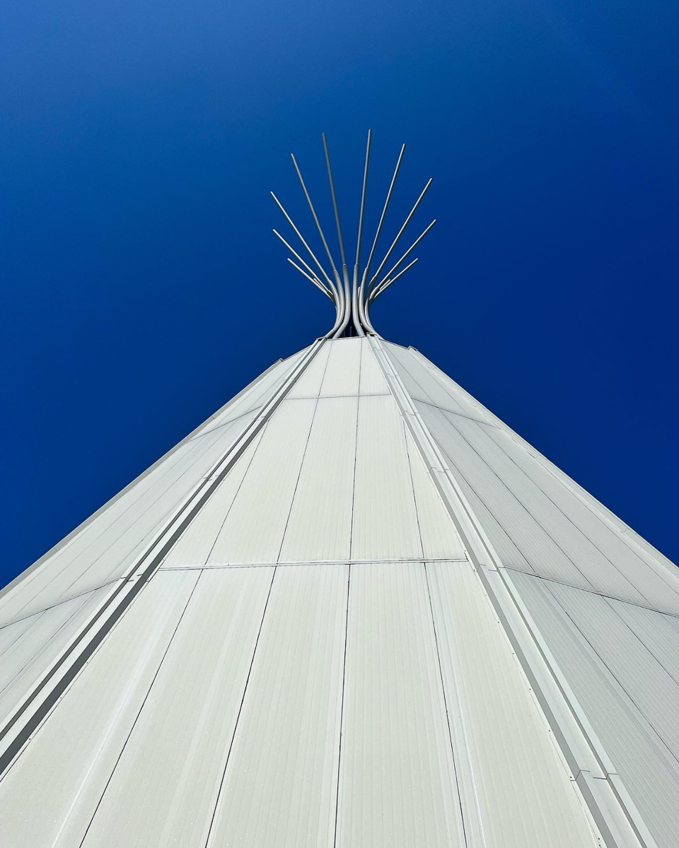 white teepee posts in front of blue sky