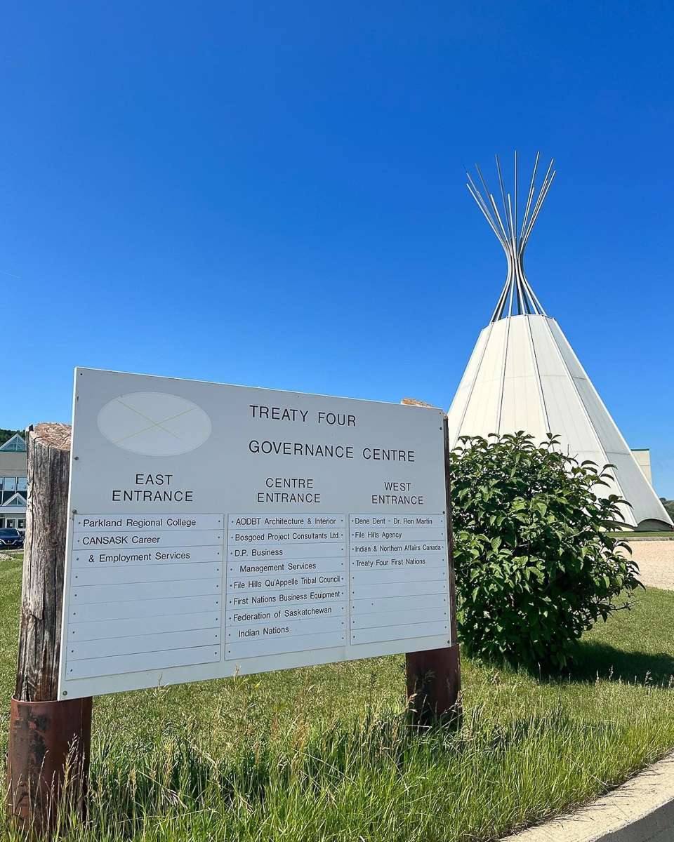 image of signs expaling treaty four in grass and teepee in background