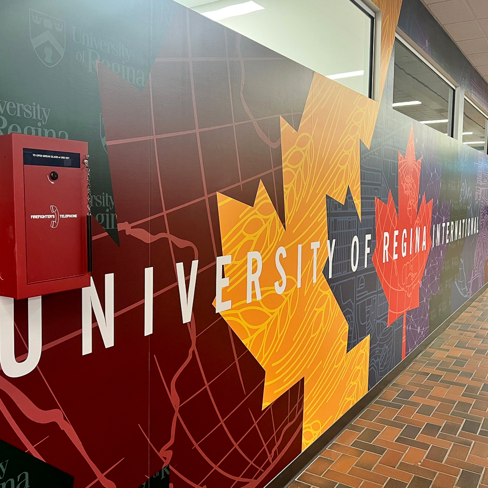 colorful maple leaf wall banner reading "university of regina international"