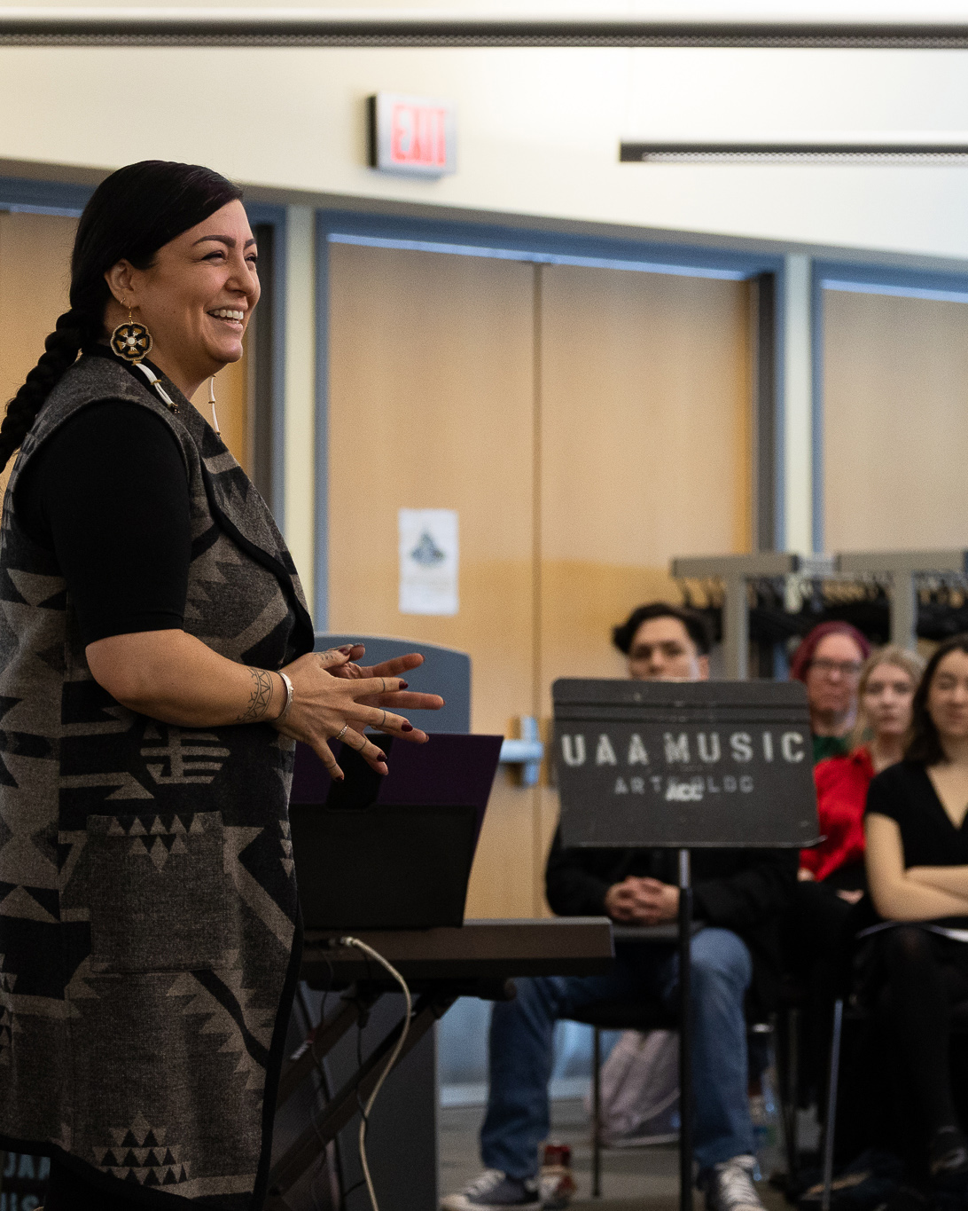 jessica ross speaking to crowd sitting in chairs infront of projector screen