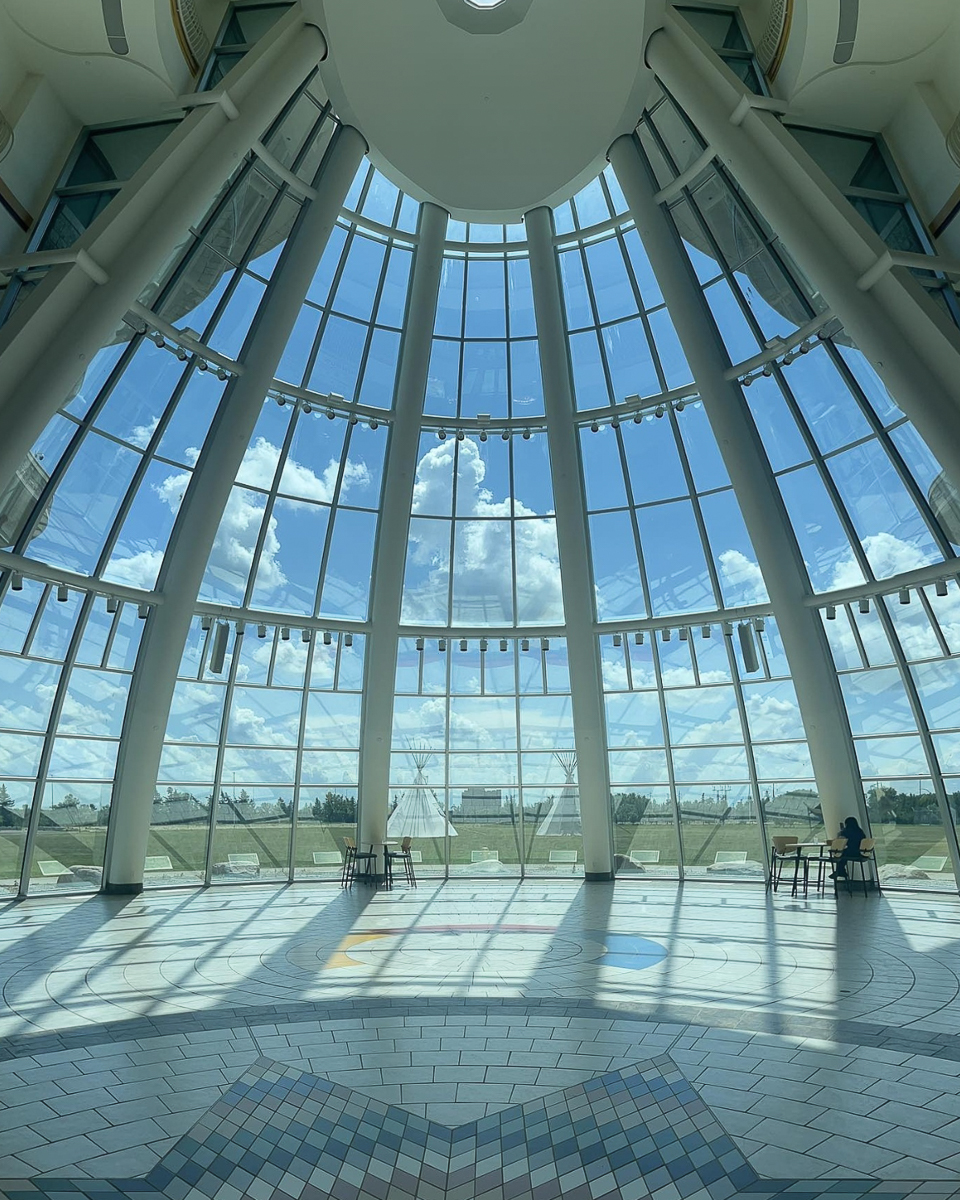 room with indigenous star pattern on floor and glass teepee shaped entrance