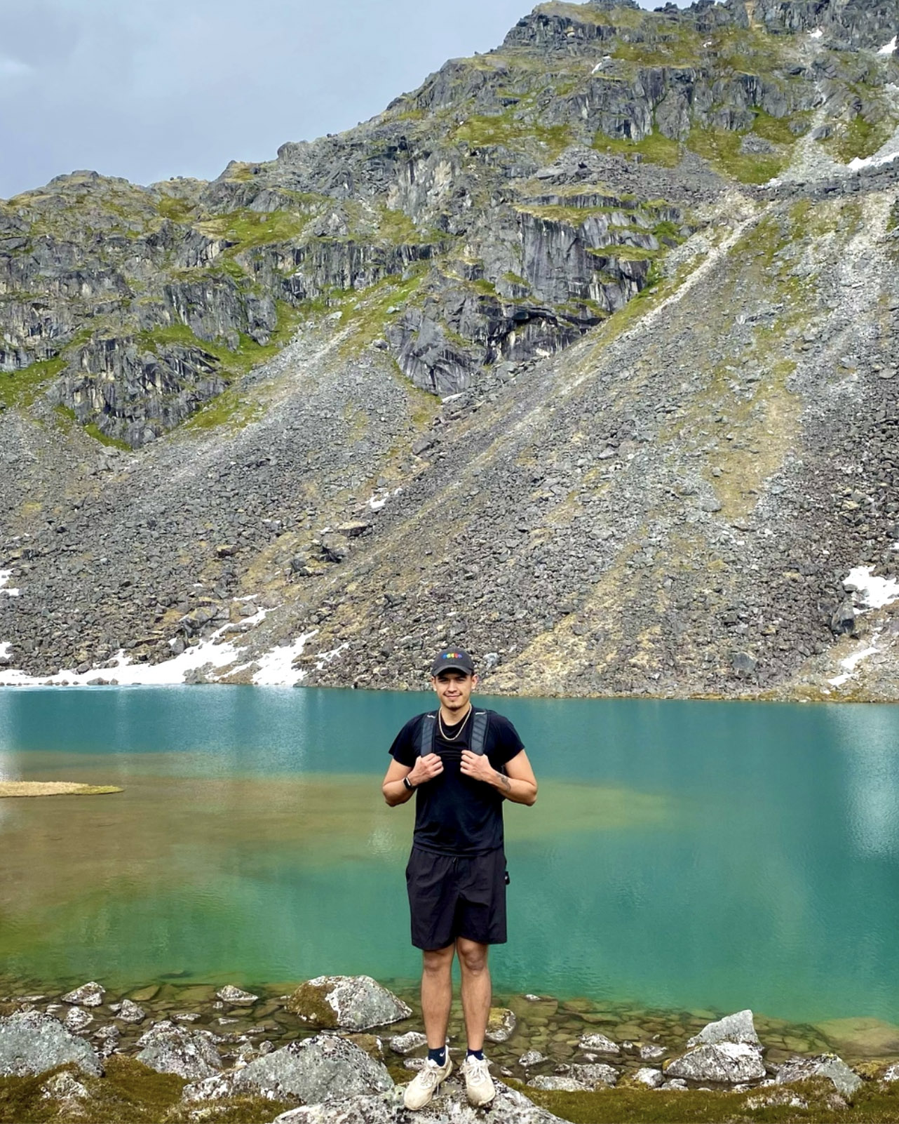 rj michael standing on rock in front of glacier and water