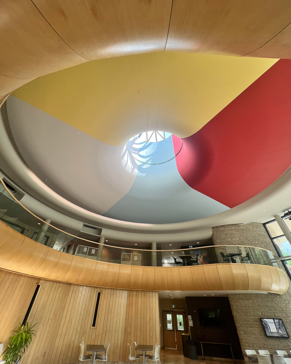 interior of curved curved, wooden room with red, white, blue and yellow ceiling
