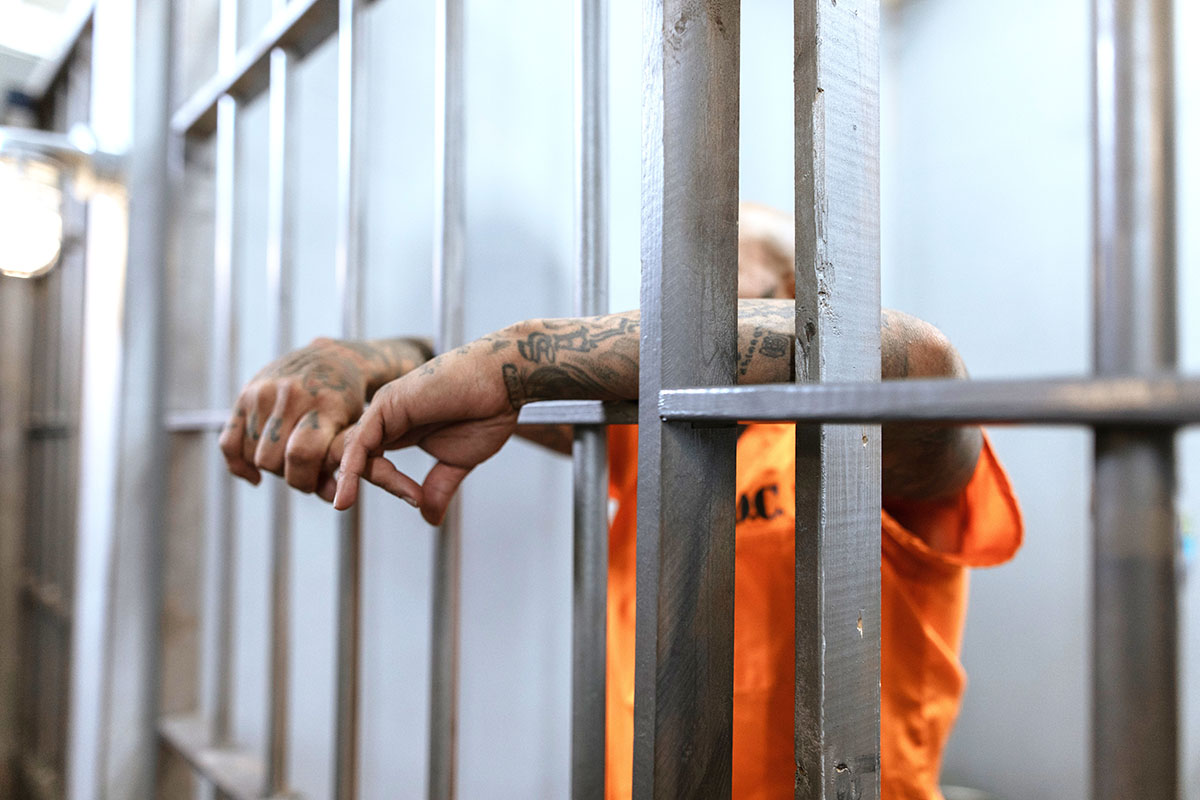 A prisoner behind bars at corrections