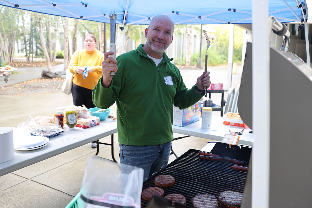 Professor Brad Myrstol fires up the grill during the Return to Campus BBQ event that the Justice Center hosted for its returning students on Sept. 8, 2022, at the Professional Studies Building of the University of Alaska Anchorage. (Photo by Ahliil Saitanan/College of Health Dean's Office)