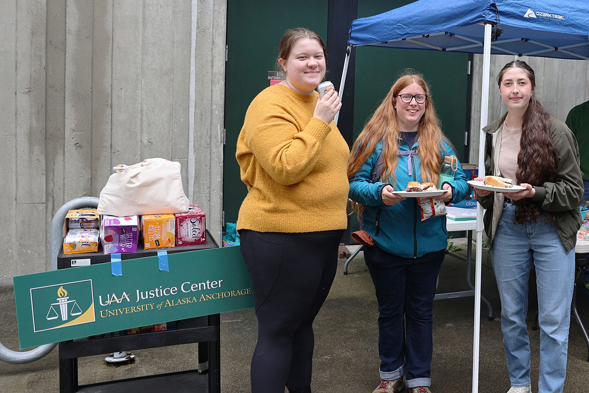 Students Rhiannon Horton, left; Kasey Dixson, center; and Elena Konev enjoy some burgers and hotdogs during the Return to Campus BBQ event the Justice Center hosted for its returning students on Sept. 8, 2022, at the Professional Studies Building of the University of Alaska Anchorage. (Photo by Ahliil Saitanan/College of Health Dean's Office)