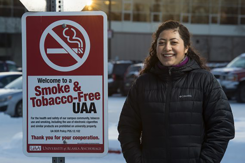 Valeria Delgado posting by smoke free UAA sign