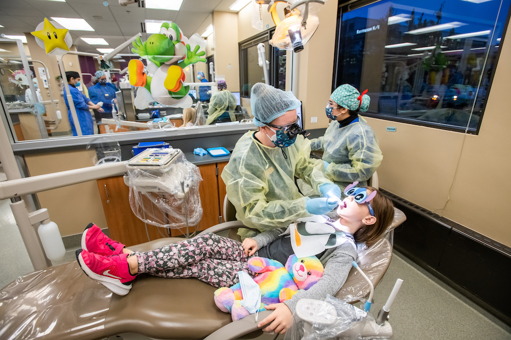 dental students providing a dental exam to a young child