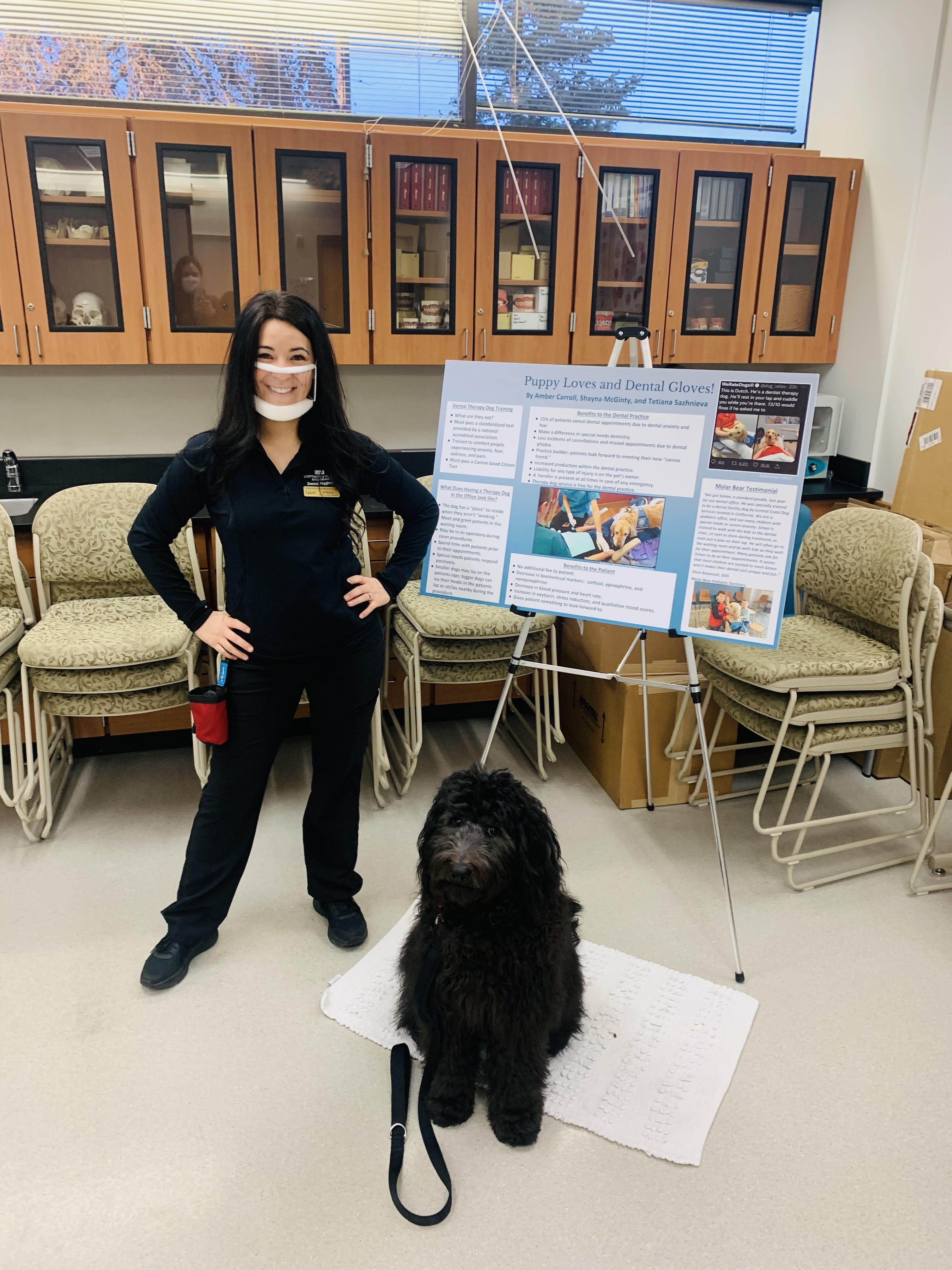 dental hygiene student presenting research poster with dog