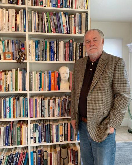 man standing by bookshelf