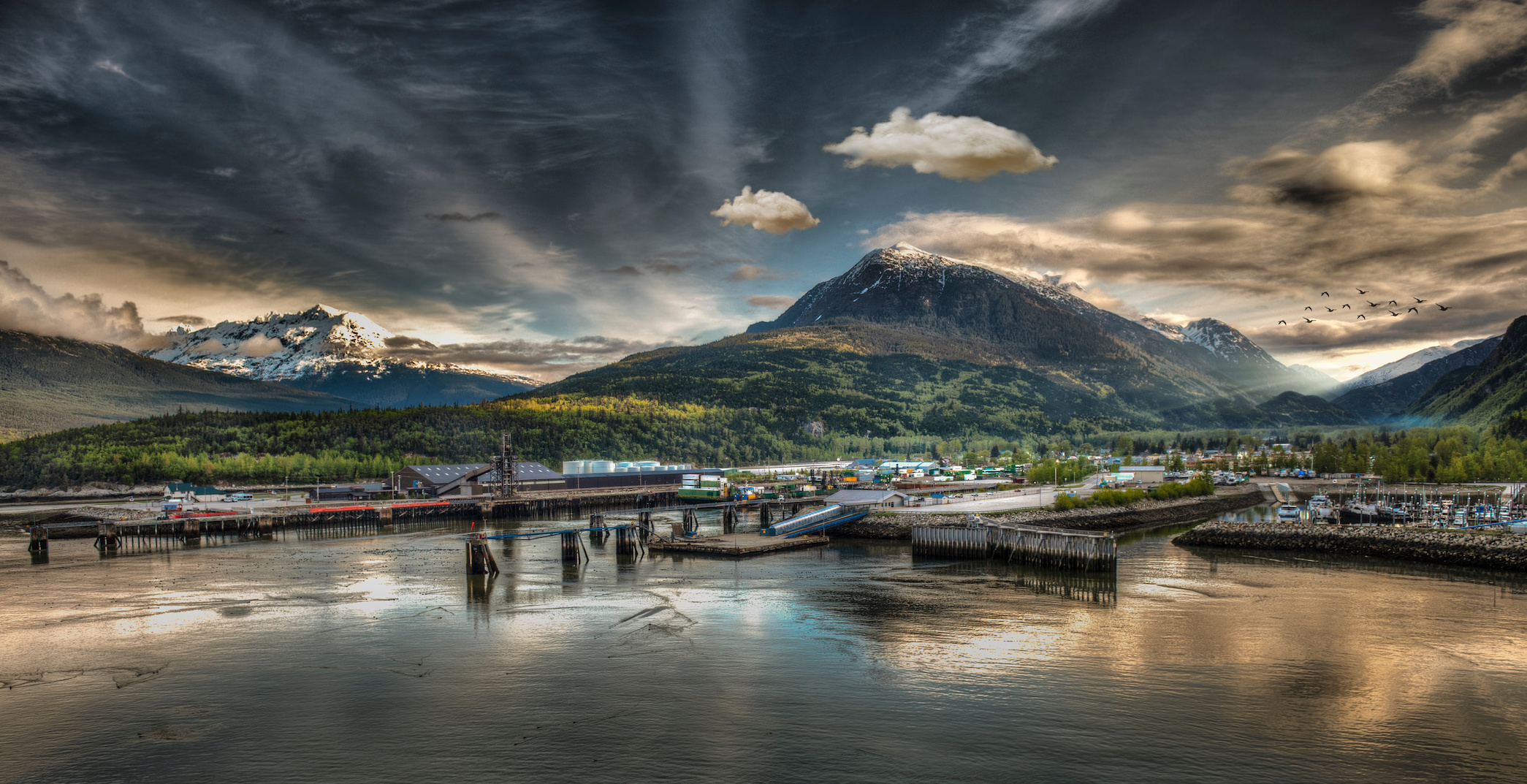boats and dock in water in front of mountain