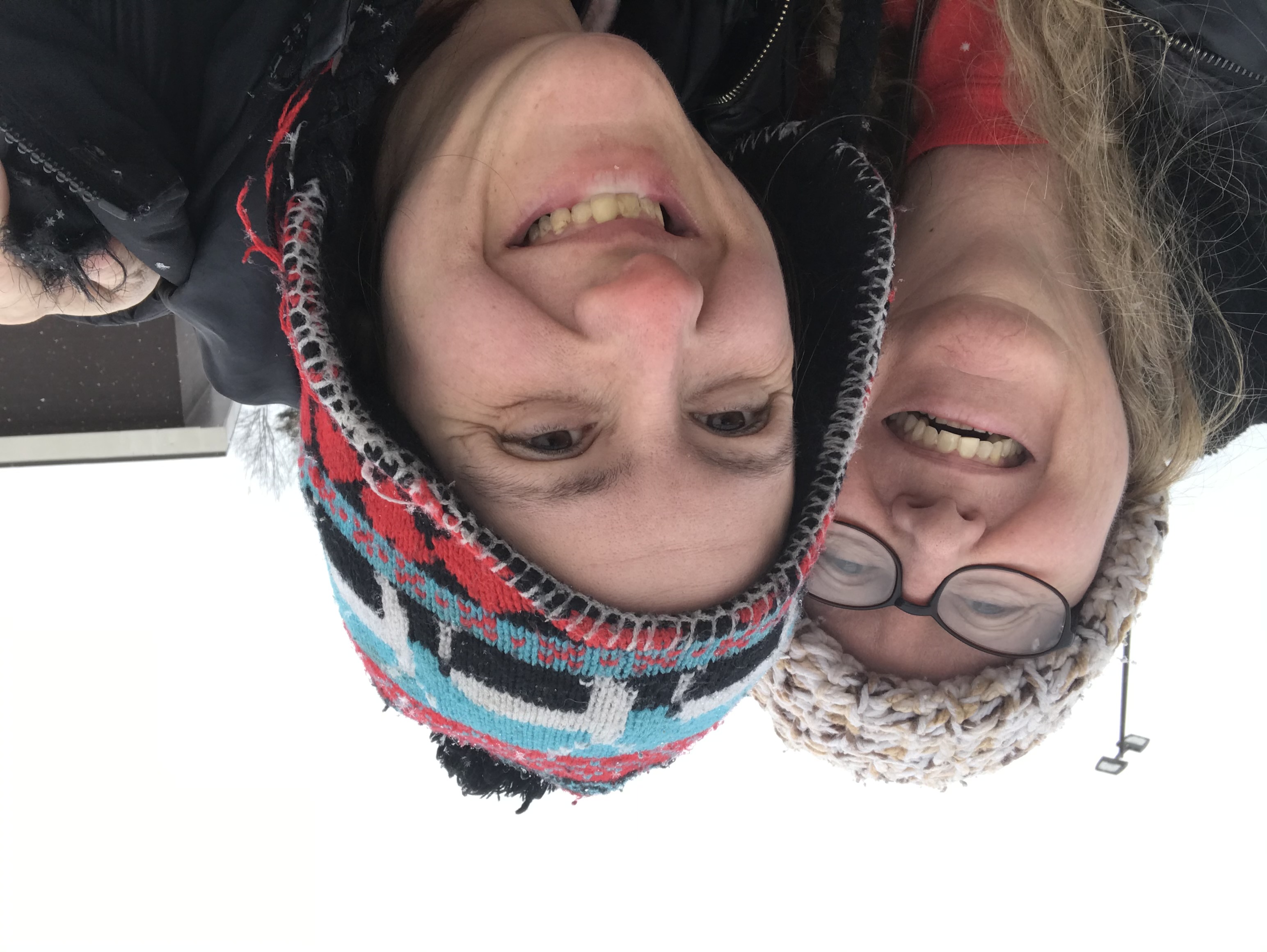 Billie takes a selfie with her daughter. Both are wearing knit beanie hats and smiling at the camera. 