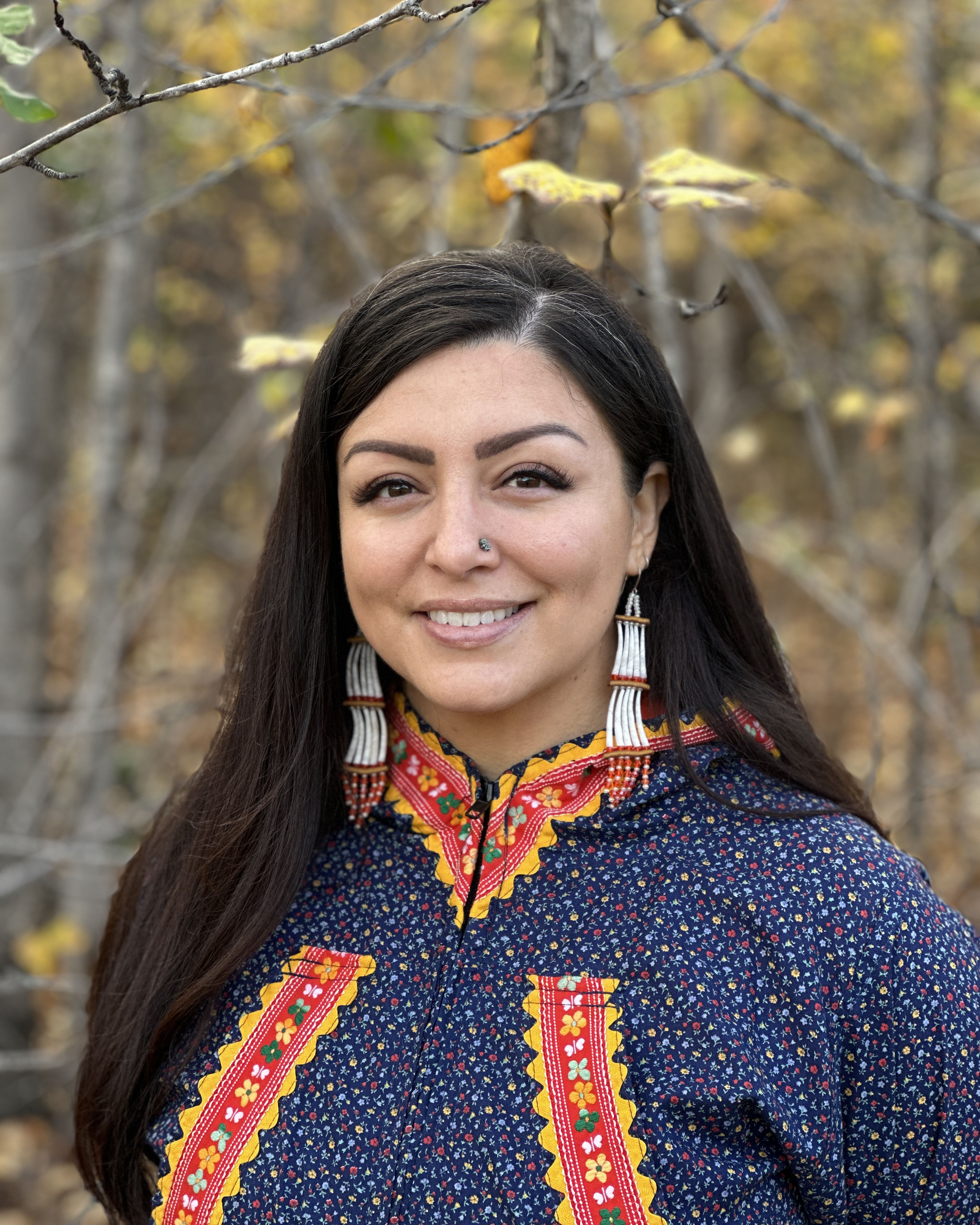 jessica ross smiling in front of trees with yellow leaves 