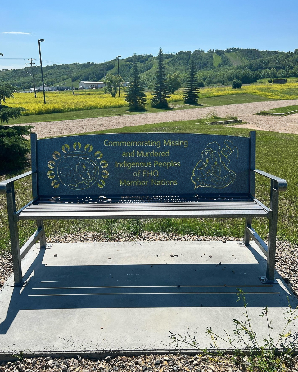 a metal bench with engraving in green field