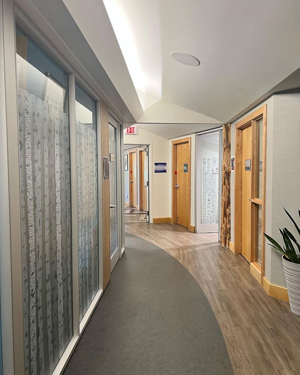 curved hallway with doors on right and frosted glass windows on left