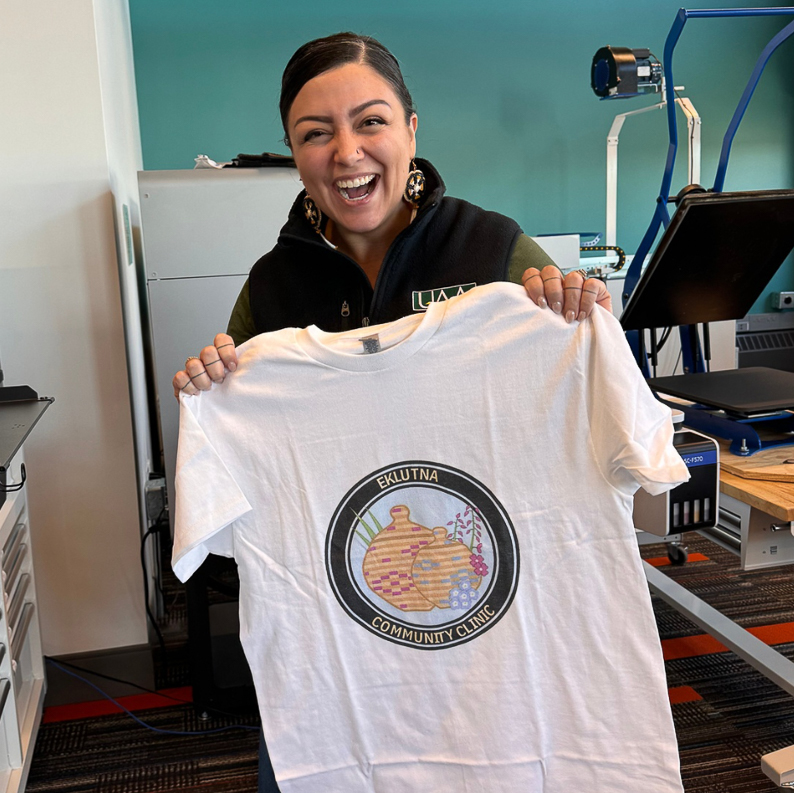 jessica ross smiling and holding eklutna community clinic teeshirt