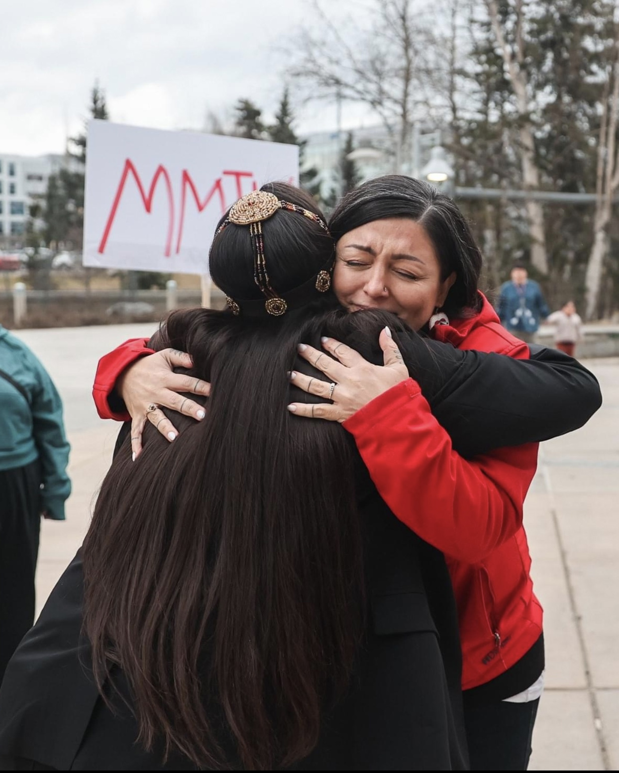 jessica ross hugging person on sidewalk