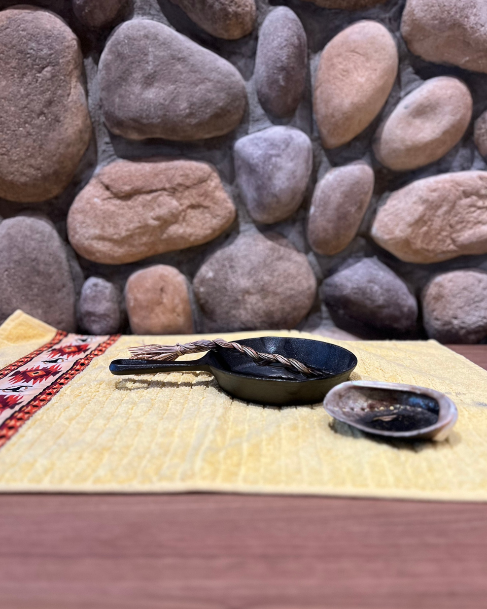 sweetgrass rope in black pan nect to abalone shell on yellow placematt