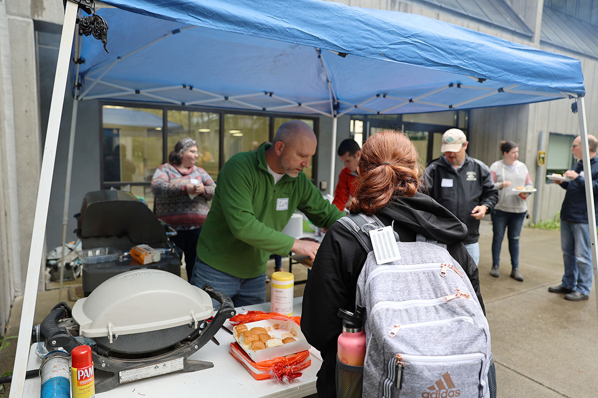 Professor Brad Myrstol serves up food during the Return to Campus BBQ event the Justice Center hosted for its returning students on Sept. 8, 2022, at the Professional Studies Building of the University of Alaska Anchorage. (Photo by Ahliil Saitanan/College of Health Dean's Office)