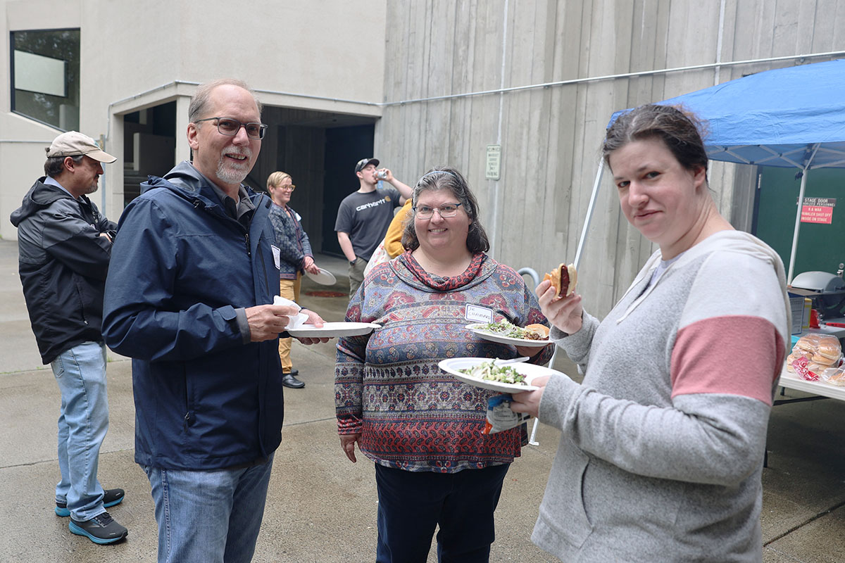 Justice Center associate professor Ron Everett, left; professor Sharon Chamard, center; and Justice senior Caitlin Cushing enjoy some burgers and hotdogs during the Return to Campus BBQ event the Justice Center hosted for its returning students on Sept. 8, 2022, at the Professional Studies Building of the University of Alaska Anchorage. (Photo by Ahliil Saitanan/College of Health Dean's Office)