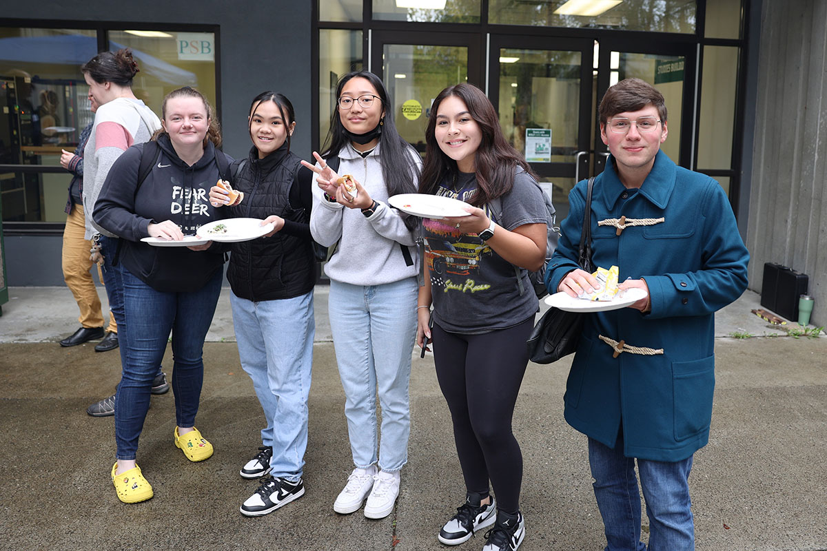 Justice Center students, from left, Madi Varnado, Kim Nguyen, Ona Baek, Victoria Vargas, and Legal Studies hopeful Mateo Jaime enjoy burgers, hotdogs, and snacks during the Return to Campus BBQ event the Justice Center hosted for its returning students on Sept. 8, 2022, at the Professional Studies Building of the University of Alaska Anchorage. (Photo by Ahliil Saitanan/College of Health Dean's Office)